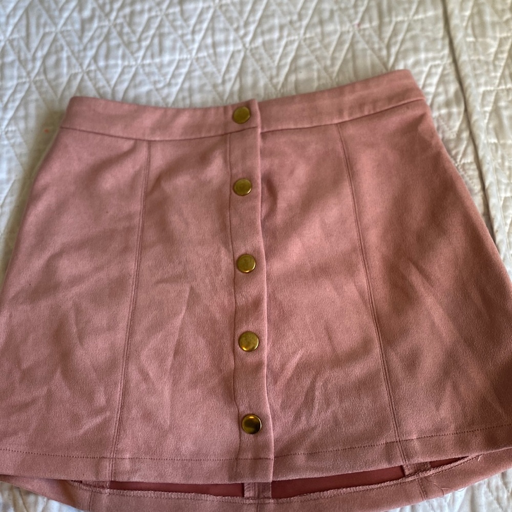 Pink skirt with gold buttons .